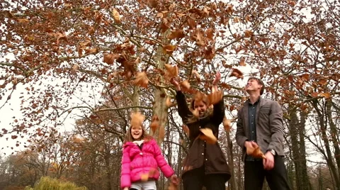 Happy family throwing leaves in the air in park Stock Footage 59554525