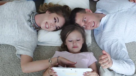 Happy family using digital tablet on floor at home Stock Footage 64107663