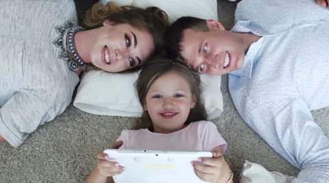 Happy family using digital tablet on floor at home Stock Footage 64110416