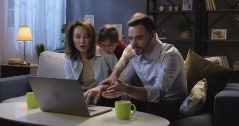 Happy family using laptop computer browsing through websites, planning vacation Stock Footage 262667471