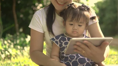 Happy family using tablet PC outdoors in autumn park Stock Footage 75684974