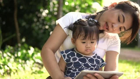 Happy family using tablet PC outdoors in autumn park Stock Footage 75685150