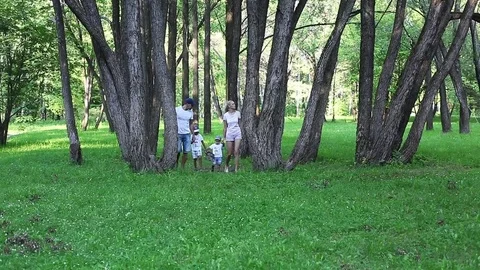 Happy family walking along the park lane on an summer day Stock Footage