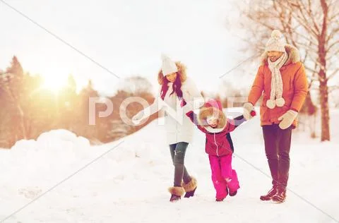 Happy family in winter clothes walking outdoors Stock Photos
