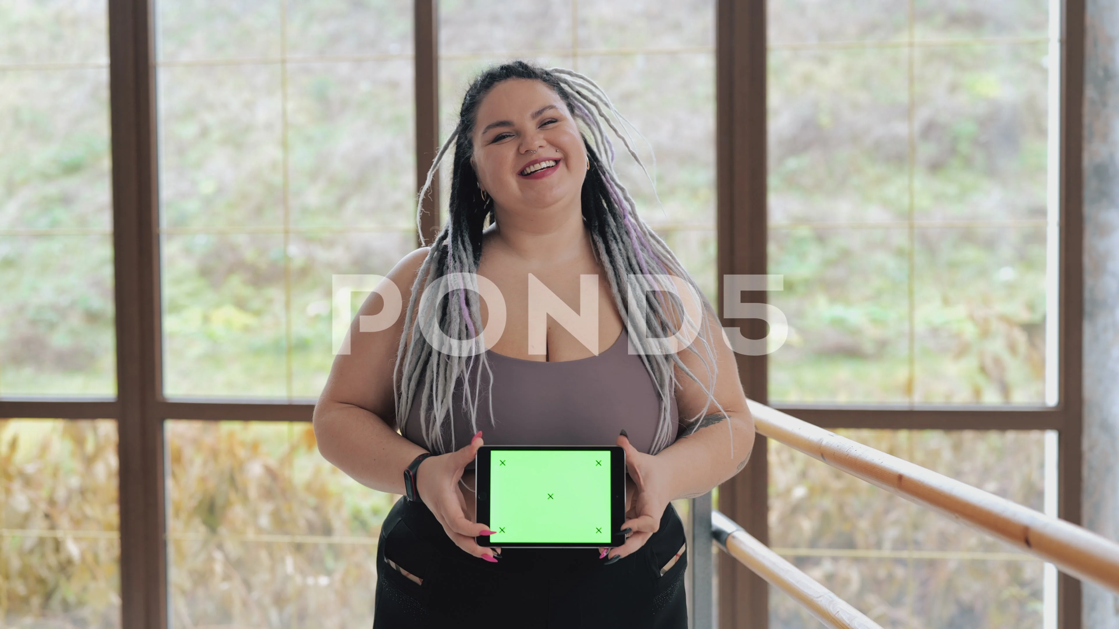 Happy fat woman in underwear with drearlocks holding green screen touch pad