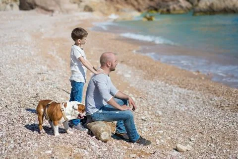 Happy father and son playing together at beach Stock Photos