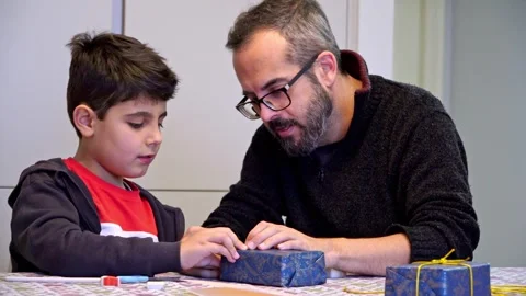 Happy father and son preparing Christmas gifts together at home Stock Footage 345253290