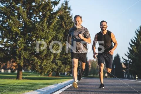 The happy father and a son running on a park road Stock Photos