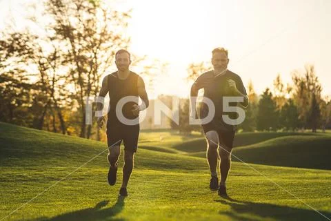 The happy father and a son running on a park grass Stock Photos