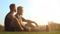 The happy father and a son sitting on the grass and talking 4k or 4k+ Resolution