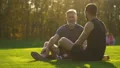The happy father and a son sitting on the grass and talking. slow motion 4k or 4k+ Resolution