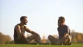 The happy father and a son sitting on the grass and talking. slow motion 4k or 4k+ Resolution
