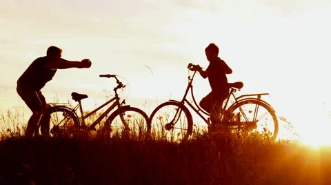 Happy father takes photos of little son near bikes in sunset lights Stock Footage