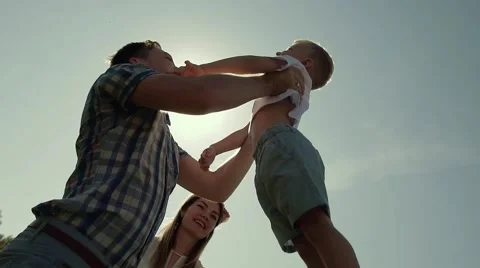 Happy father throws his son in the air and catches him. Sun rays shine brightly Stock-Footage 68205740