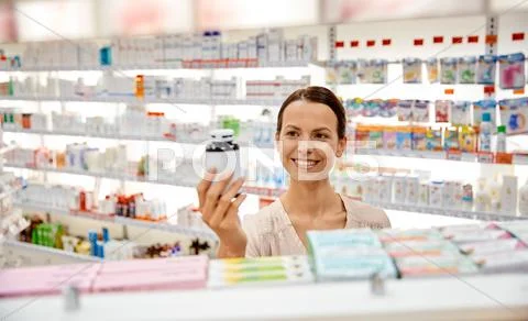 Happy female customer with drug jar at pharmacy Stock Photos