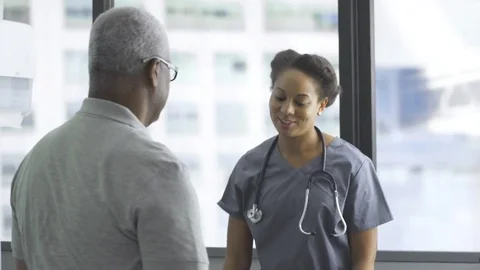 Happy female doctor embracing senior male patient in clinic Stock Footage