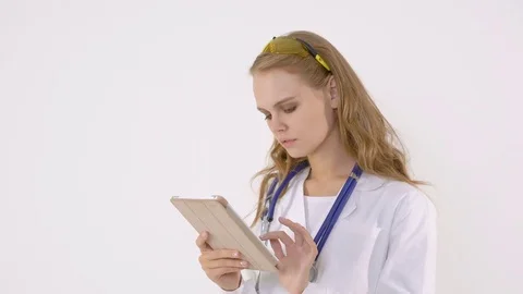 Happy female doctor using tablet computer on a white background Stock Footage 82167807