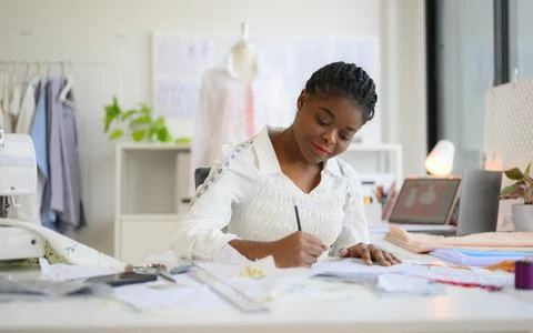 Happy female dressmaker working in workshop studio Stock Photos
