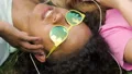 Happy female friends in earphones listening to music together, lying on grass HD Footage