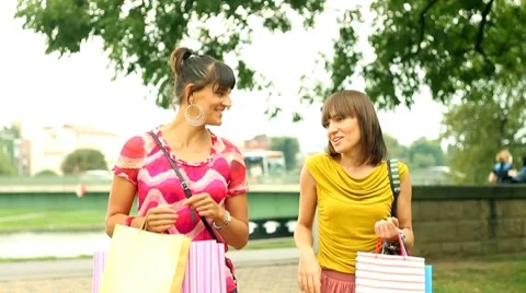 Happy female friends with shopping bags walking in the city, steadycam shot Stock Footage