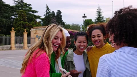 Happy female group using mobile phone together outdoors. Stock Footage 265712008