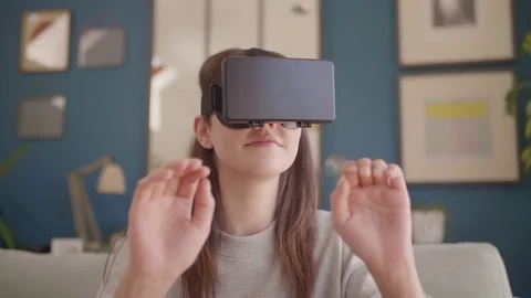 Happy female hipster using virtual reality simulator at home Stock Footage 79658845
