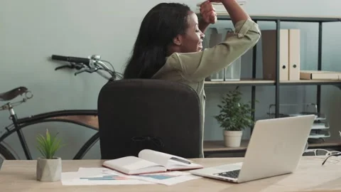 Happy female office worker having fun sitting at her desk celebrating the Stock Footage 148243255