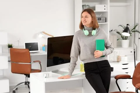 Happy female programmer with computer, notebook and headphones working in off Stock Photos