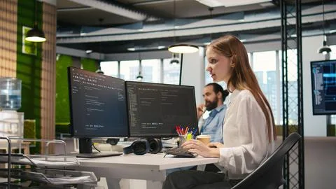 Happy female programmer dancing on office desk chair Stock Photos