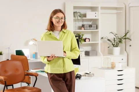 Happy female programmer with laptop working in office Stock-Fotos