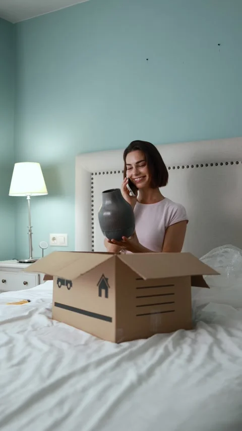 Happy female shopper opening package while speaking Stock Footage 334570211