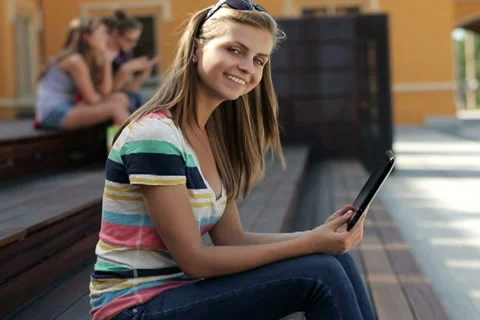 Happy female student with tablet computer in the city, steadicam shot NTSC Stock Footage 12134079