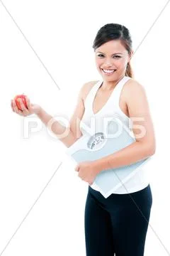 Happy fitness woman holding weight scale and apple Stock Photos