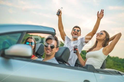 The happy five people sit in the cabriolet Stock Photos