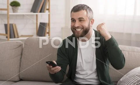 Happy football fan watching sports on tv at home Stock Photos