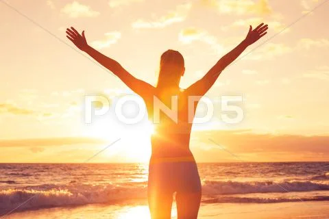 Happy free woman at sunset on the beach Stock-Fotos
