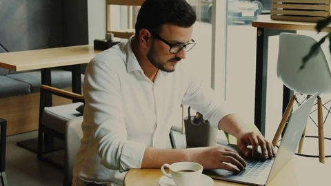 Happy freelancer finished his work at the computer in modern loft cafe Stock Footage 112995157
