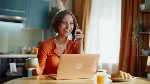 Happy freelancer talking mobile phone holding coffee cup in kitchen closeup. Stock Footage 333775917