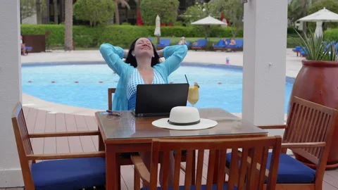 Happy freelancer working on laptop while relaxing at resort in summer Stock Footage 251671169