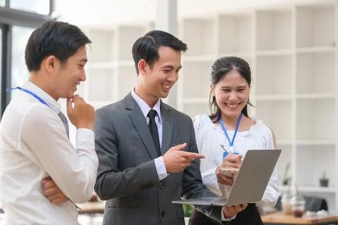 Happy friendly business team using laptop, working together on a new projec.. Stock Photos