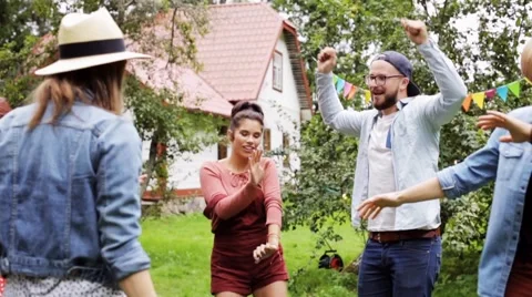 Happy friends dancing at summer party in garden Stock Footage