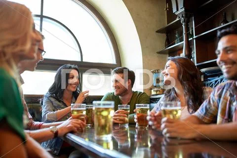 Happy friends drinking beer at bar or pub Stock Photos