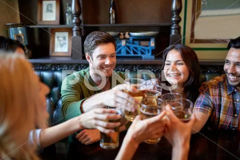 Happy friends drinking beer at bar or pub Stock Photos