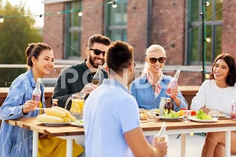 Happy friends with drinks at rooftop party Stock Photos
