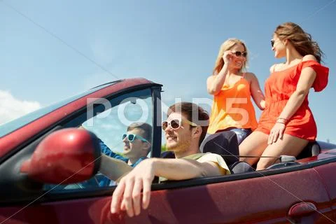 Happy friends driving in cabriolet car Stock Photos