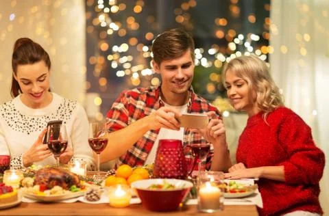 Happy friends having christmas dinner at home Stock Photos