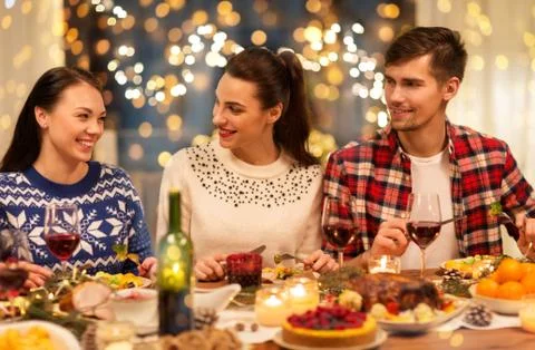 Happy friends having christmas dinner at home Stock Photos
