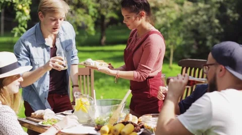 Happy friends having dinner at summer garden party Stock Footage