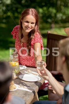 Happy friends having dinner at summer garden party Stock Photos