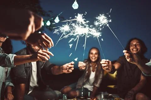Happy friends having fun outdoors. Cheerful people enjoying party with sparkl Stock Photos